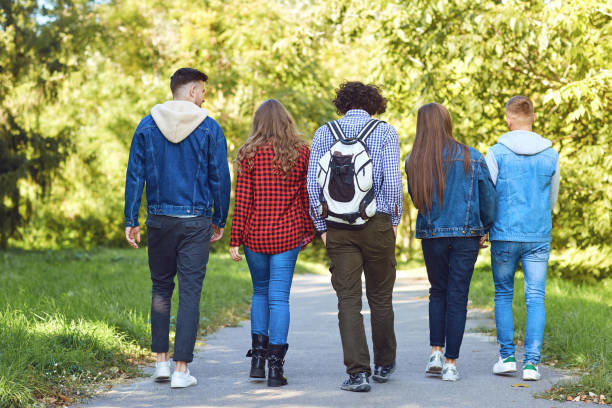 Foto de jóvenes caminando por un parque.