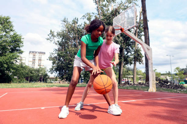 Dos niñas practicando baloncesto.